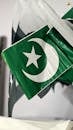 A close-up of Pakistan's national flag showcasing the crescent and star symbols.